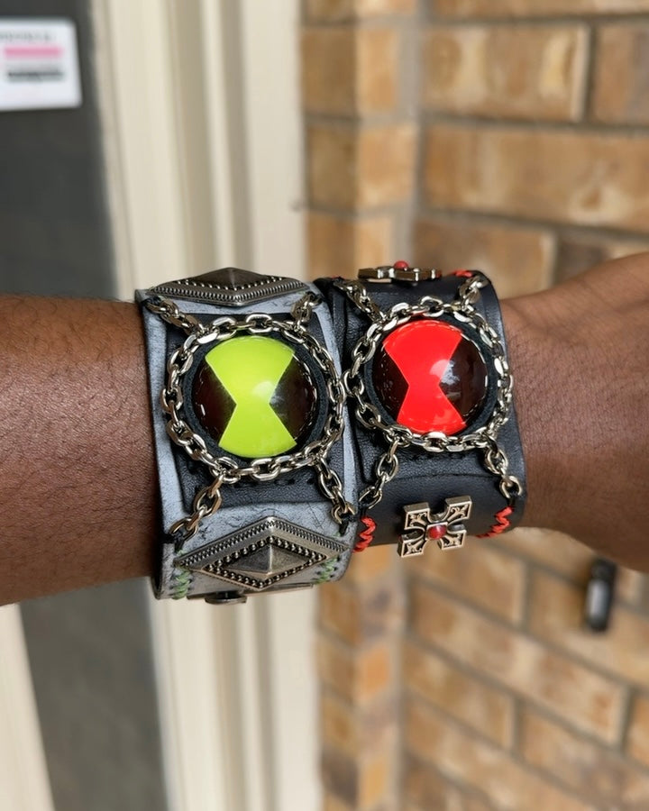red and green ben 10 omnitrix bracelet in a mans wrist.