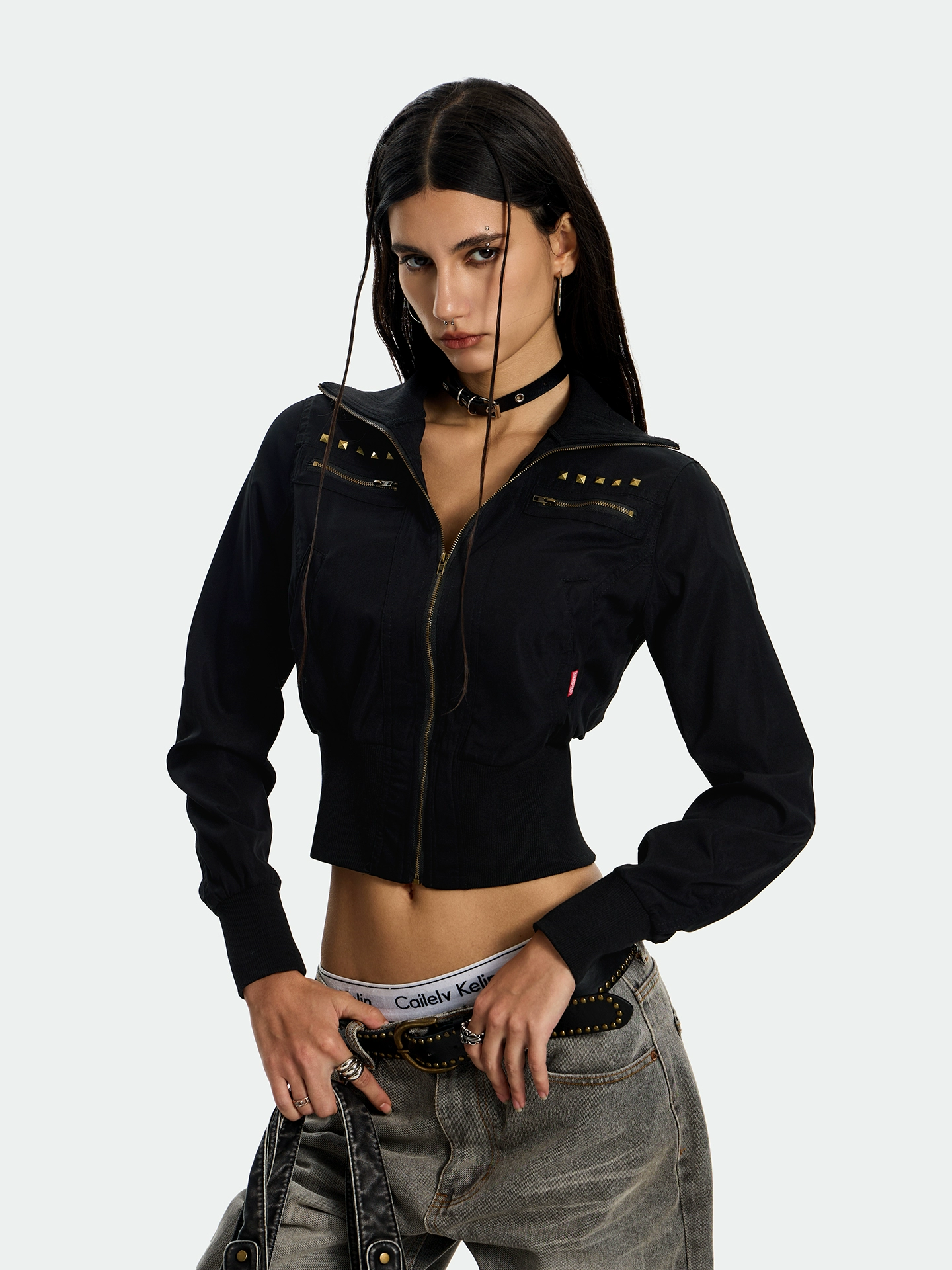 A woman with a black choker and a black handbag visible in the full-length shot.