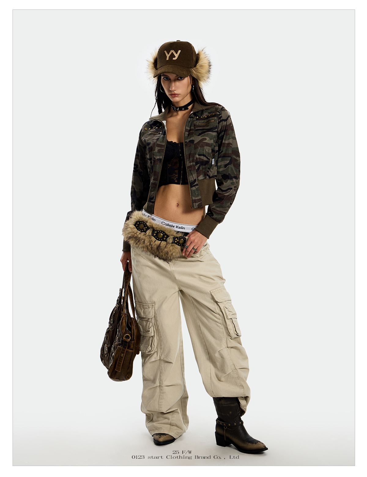 A woman modeling a cropped Rebel Camo Jacket with a matching fuzzy hat.