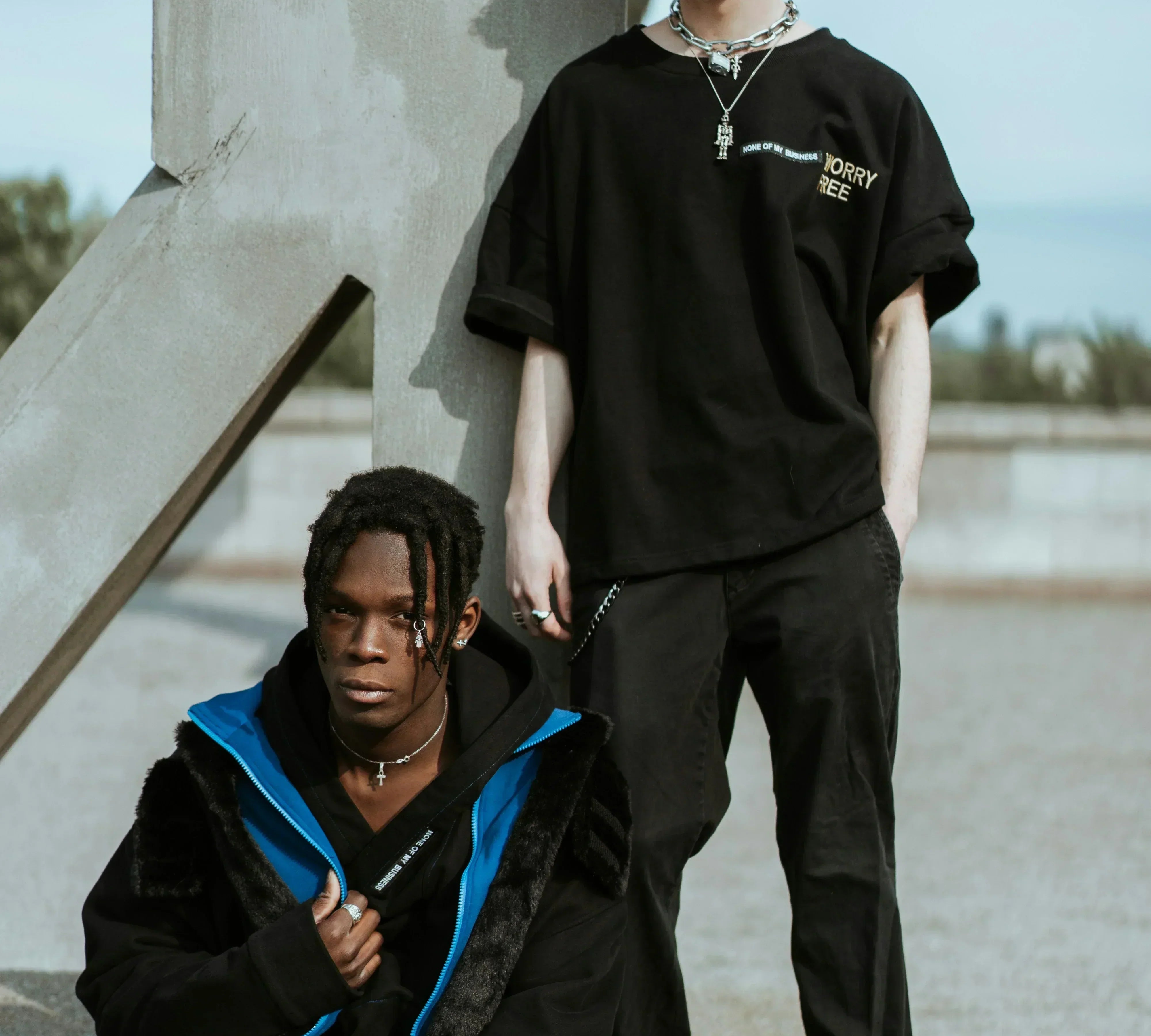 Two man  wearing dark themed outfits.
