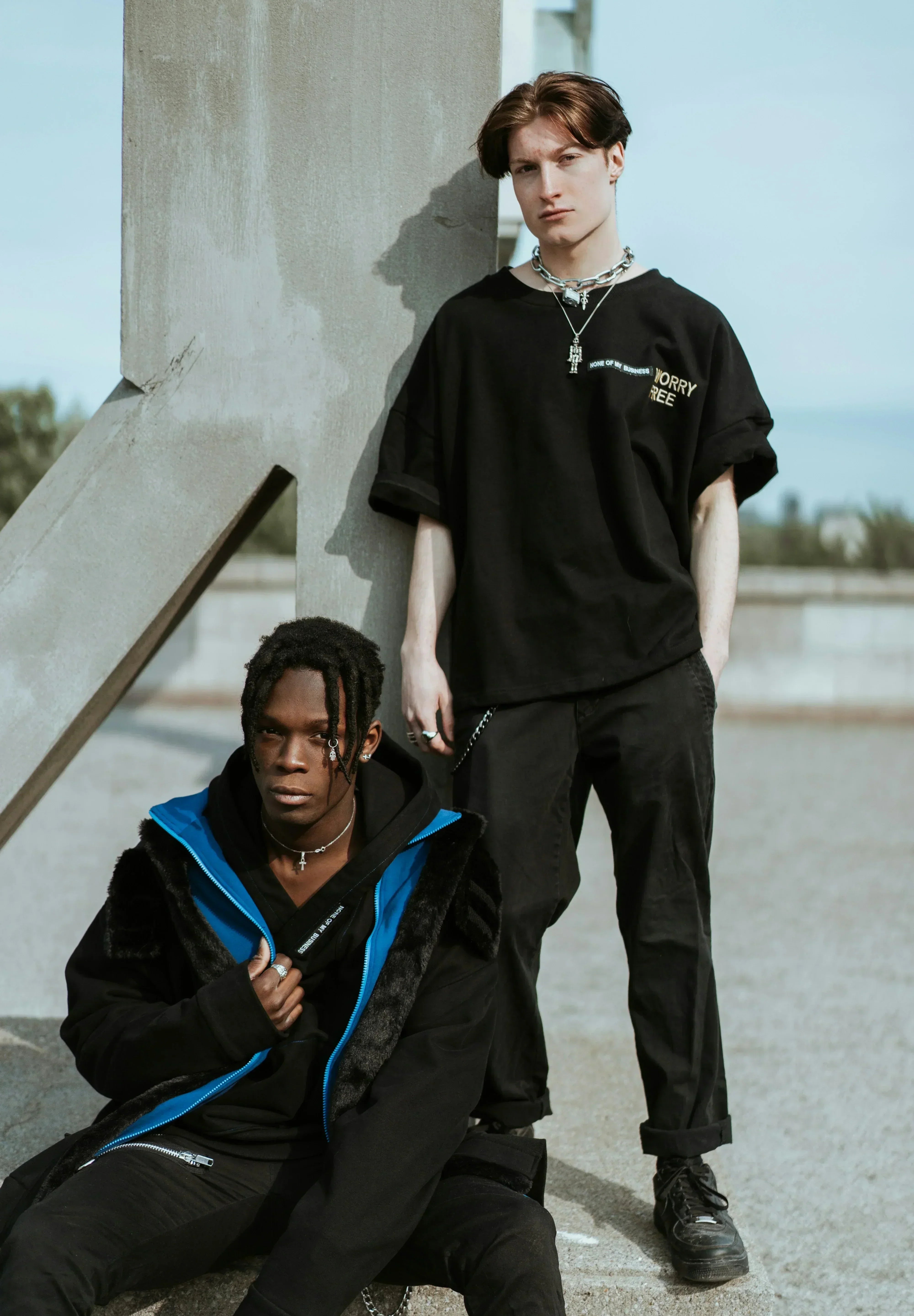 Two man  wearing dark themed outfits.