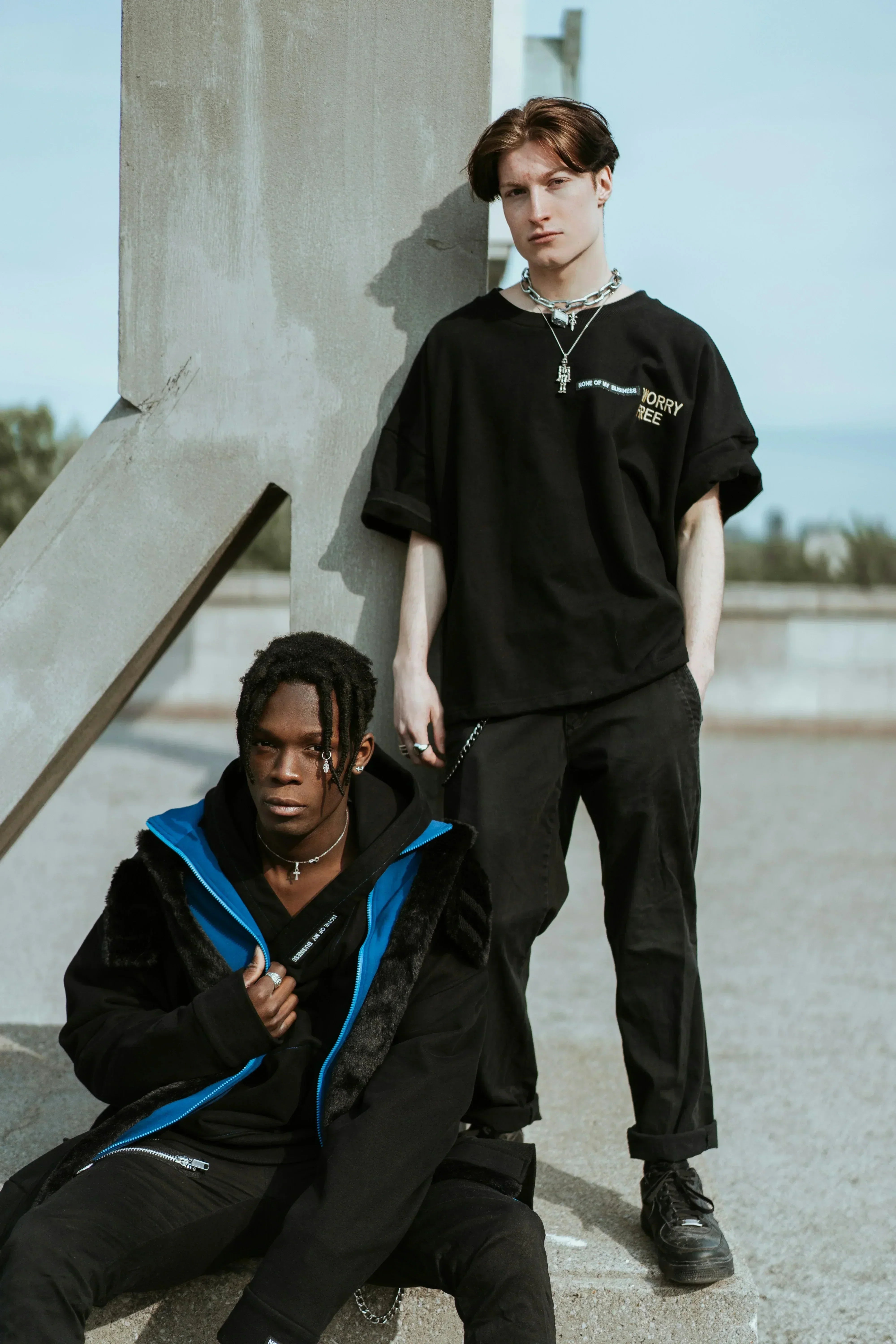 Two man  wearing dark themed outfits.