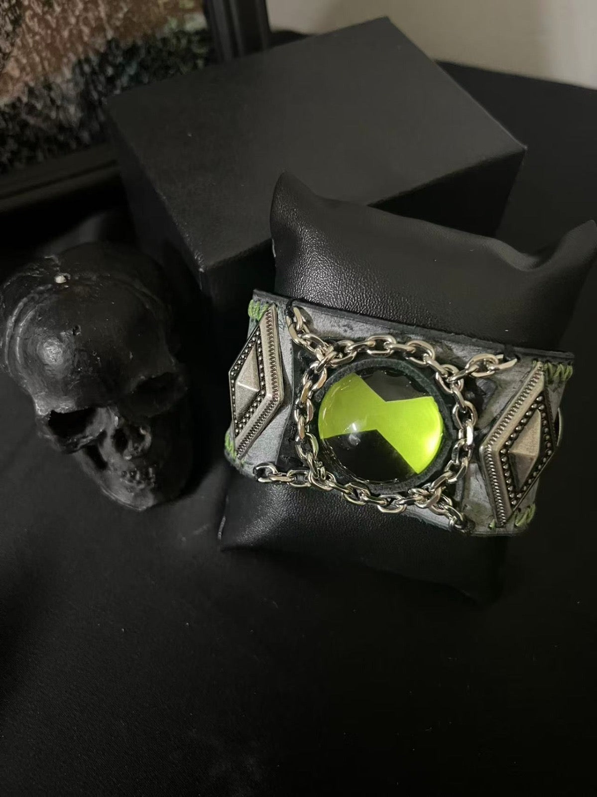 Green ben 10 omnitrix bracelet in a dark style  room.