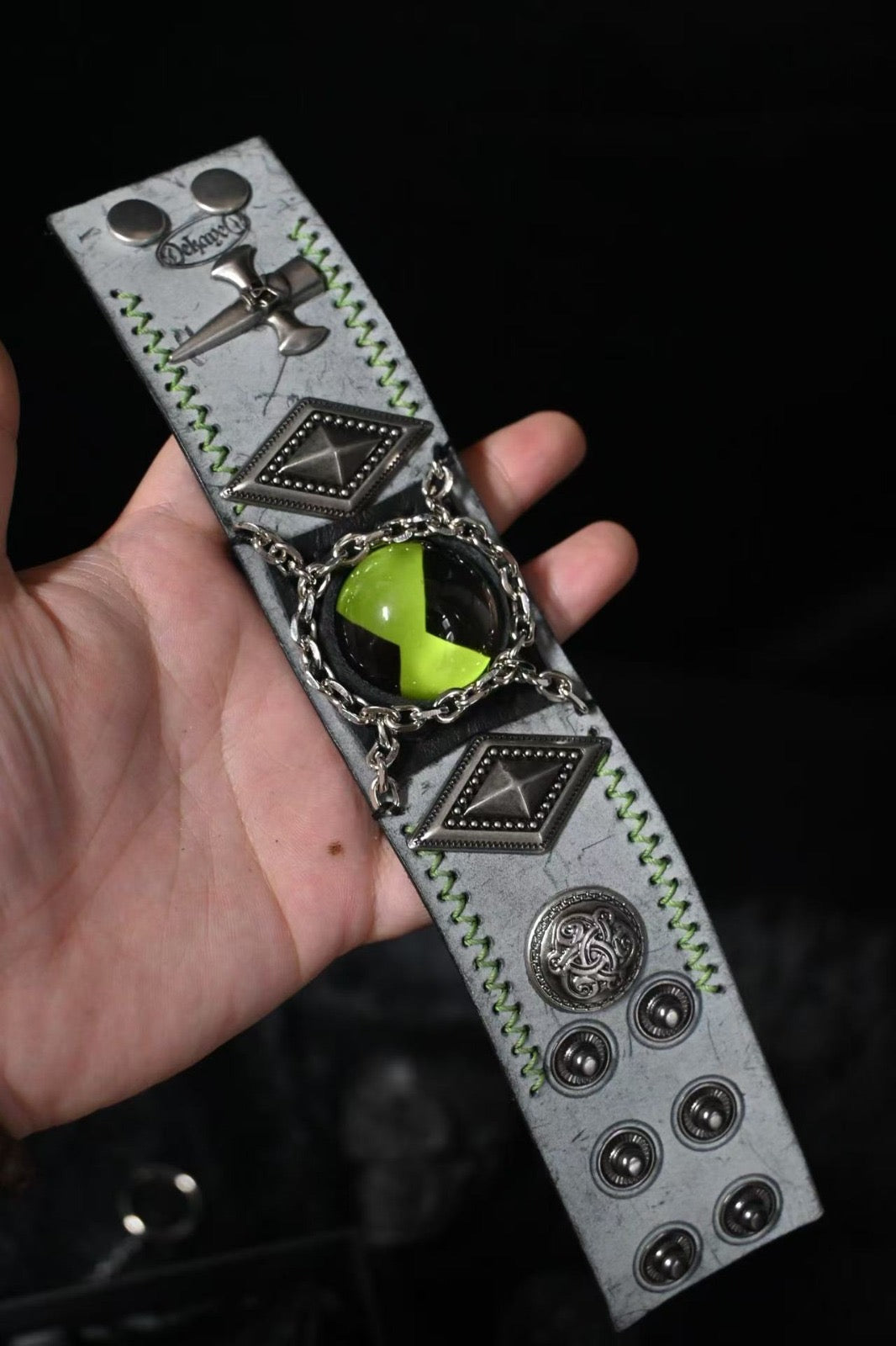 Green ben 10 omnitrix bracelet in a mans hand.
