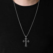 gothic cross necklace being wear by a man with black shirt.
