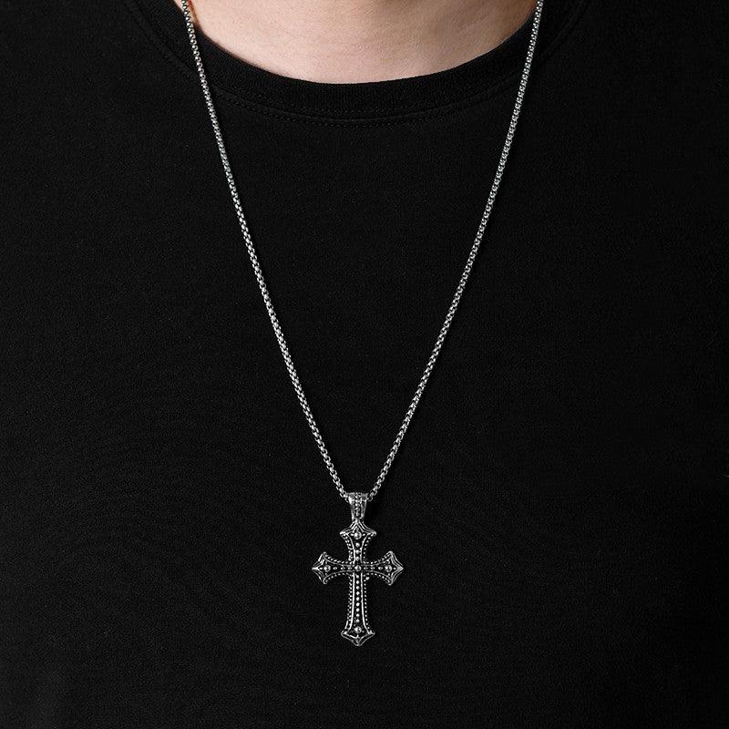 gothic cross necklace being wear by a man with black shirt.