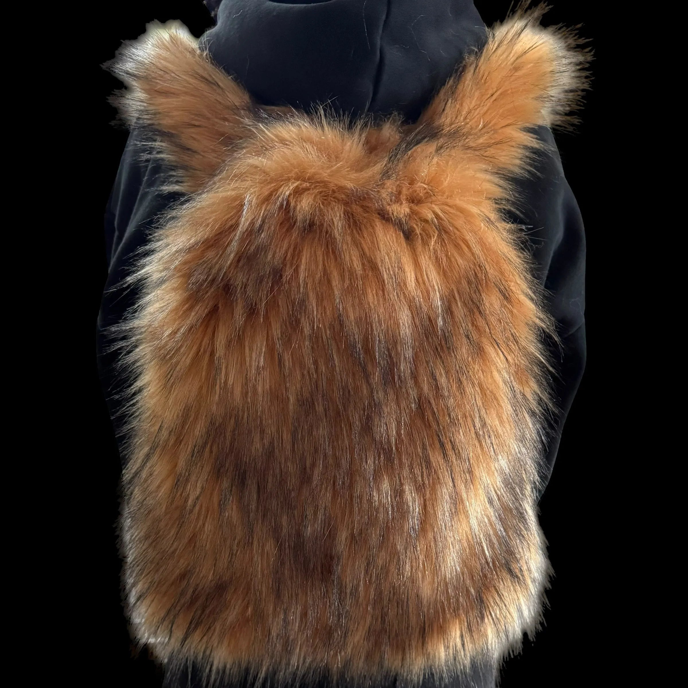 A fluffy, reddish-brown Plush Backpacks - Lost Series with hints of dark fur is worn on a person's back, set against a dark background.