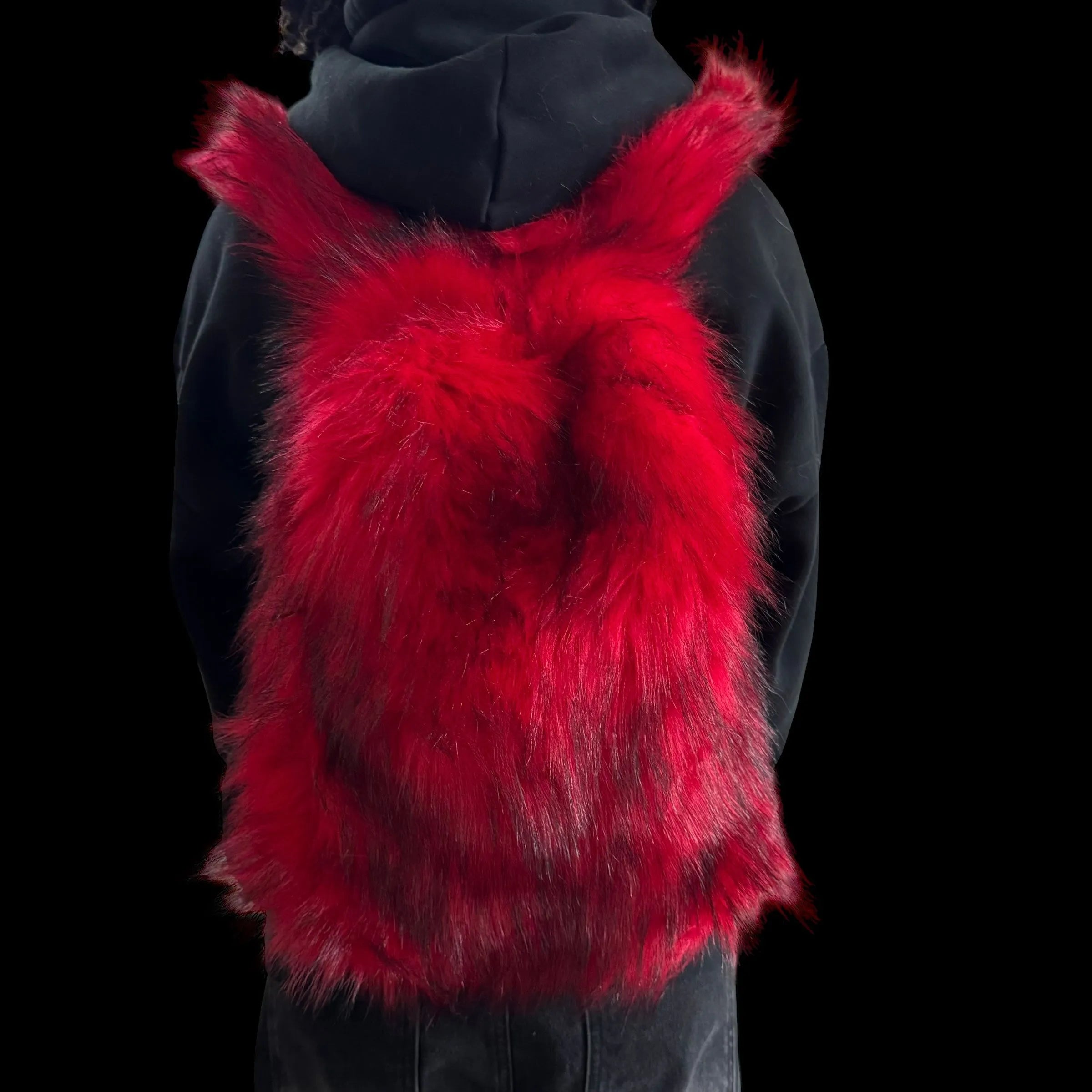 A plush red and black Plush Backpacks - Lost Series with bunny ears is worn on a person's back, set against a dark background.