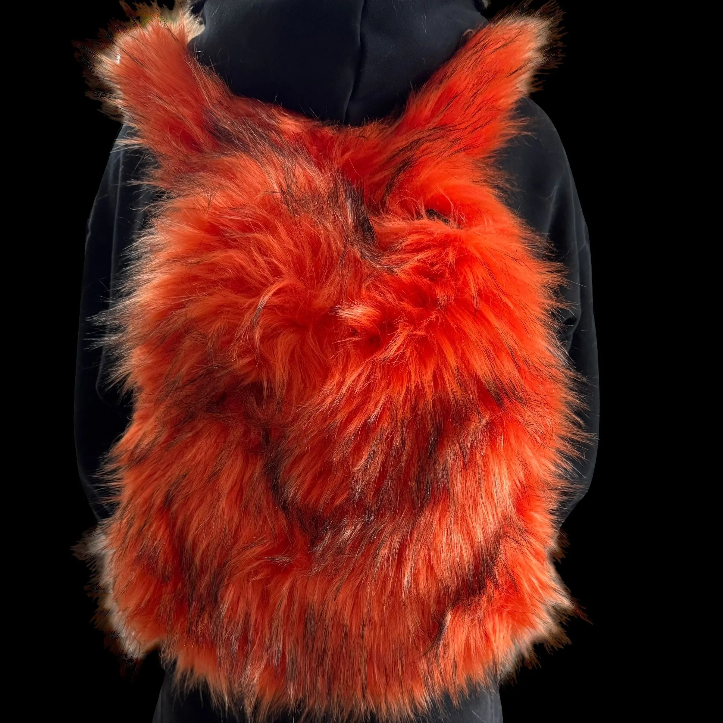 A fluffy orange and black Plush Backpacks - Lost Series with bunny ears is worn on a person's back, set against a dark background, showcasing a playful and vibrant design.