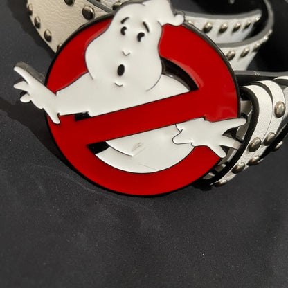 A close-up of a Ghost Busters Belt shows a large, round buckle with the classic ghost-in-a-red-circle logo on a white studded belt against a black background.