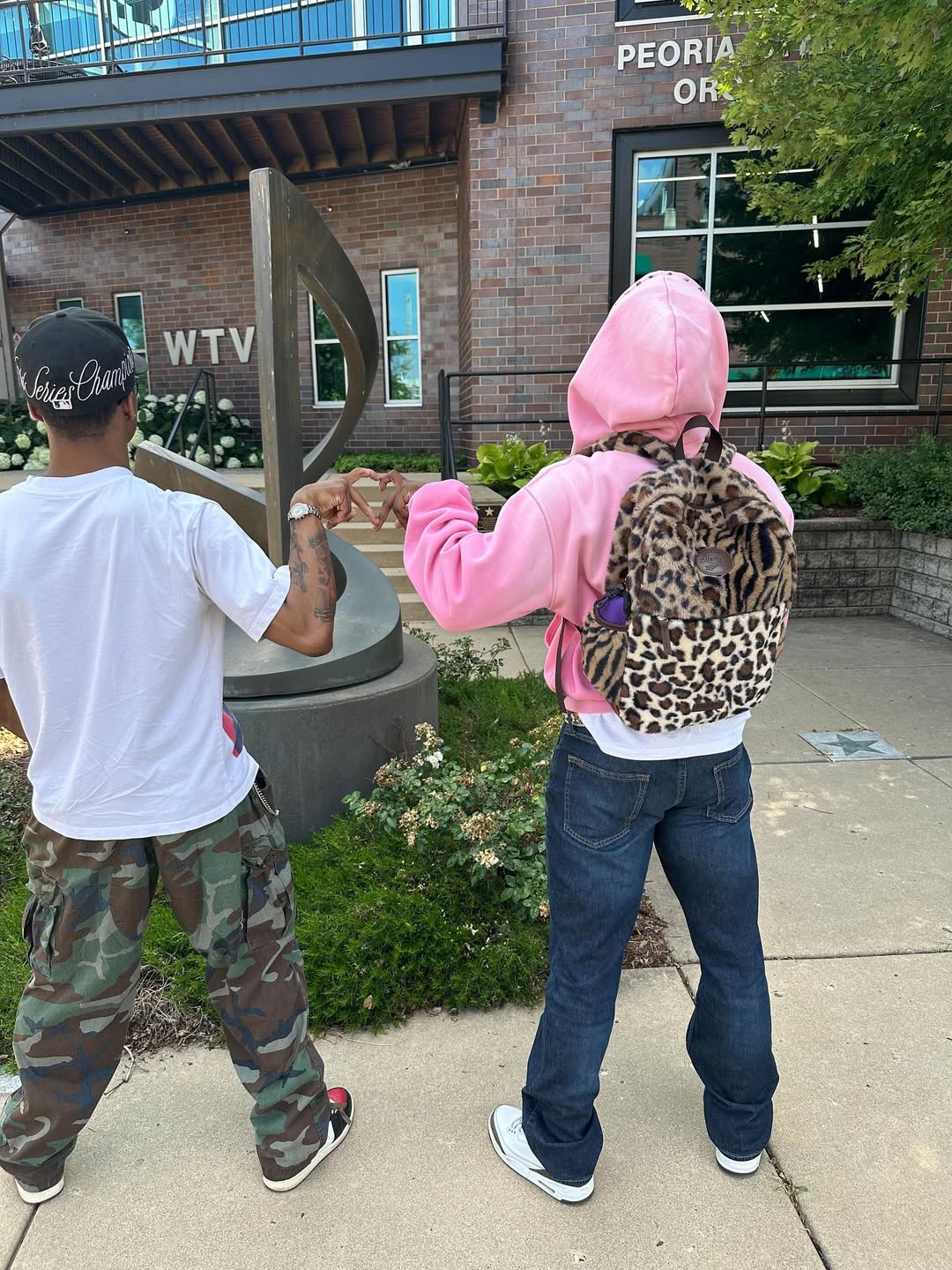 Two man standing with Limited Multi Leopard Print Plush Backpack on the back.