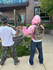 Two man wearing Limited Multi Leopard Print Plush Backpack with mixed animal patterns.