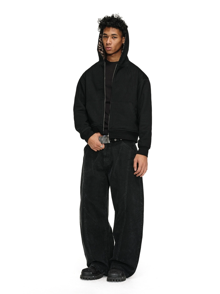 A man wearing black Leopard Jacket with a matching leopard-print lining in the hood, baggy black jeans with a striped belt, and chunky black shoes.