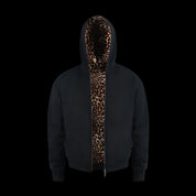 A person with dark, curly hair poses with their hands in the pockets of a black Leopard Lined Jacket