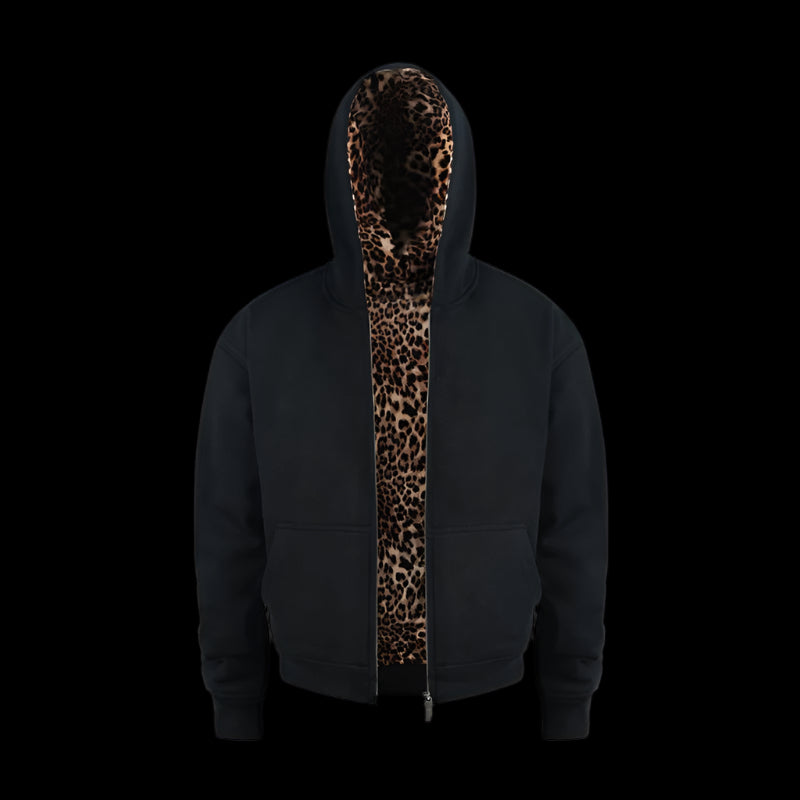 A person with dark, curly hair poses with their hands in the pockets of a black Leopard Lined Jacket
