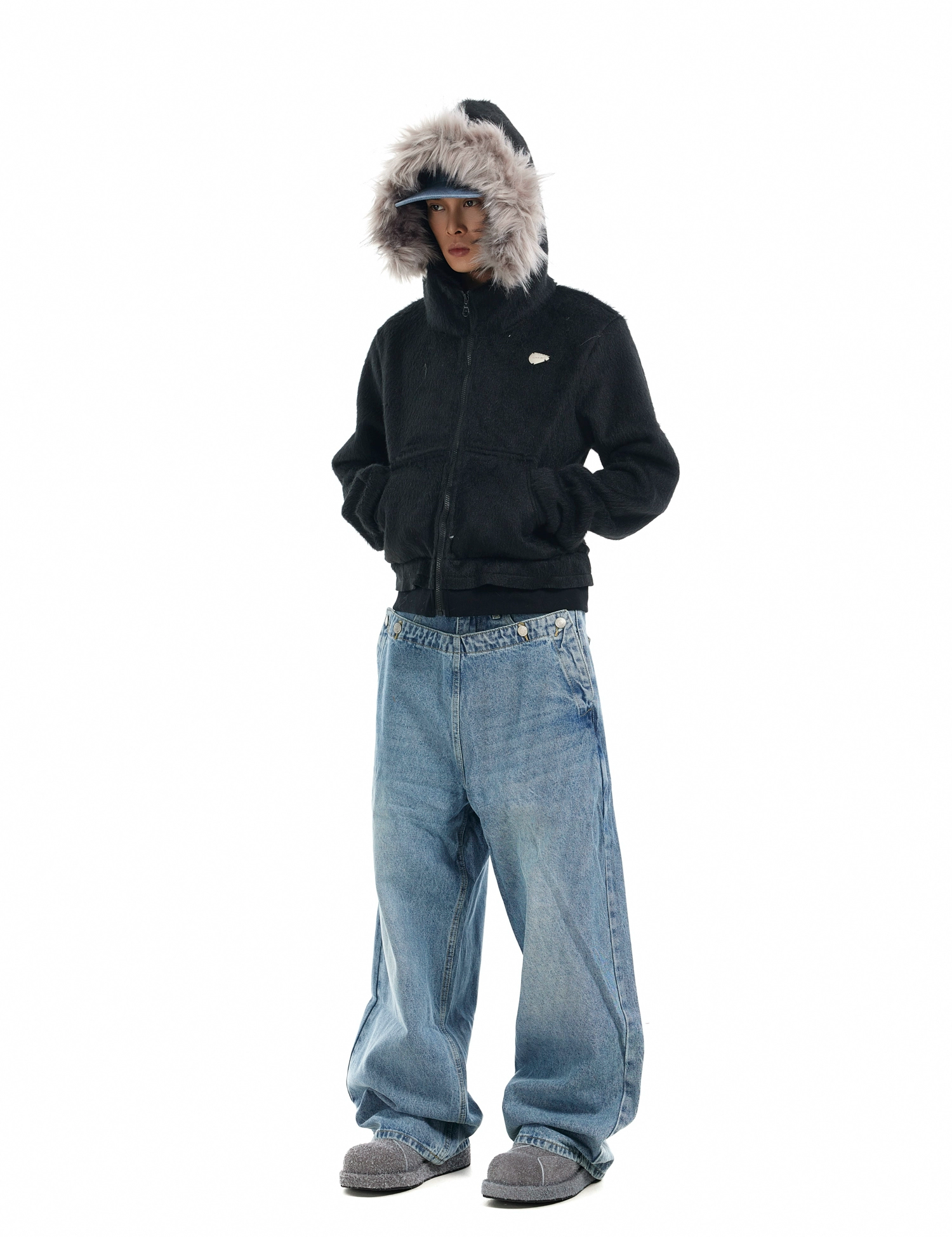 A person wears a dark "Mens Faux Fur Hooded Jacket" hands in pockets.