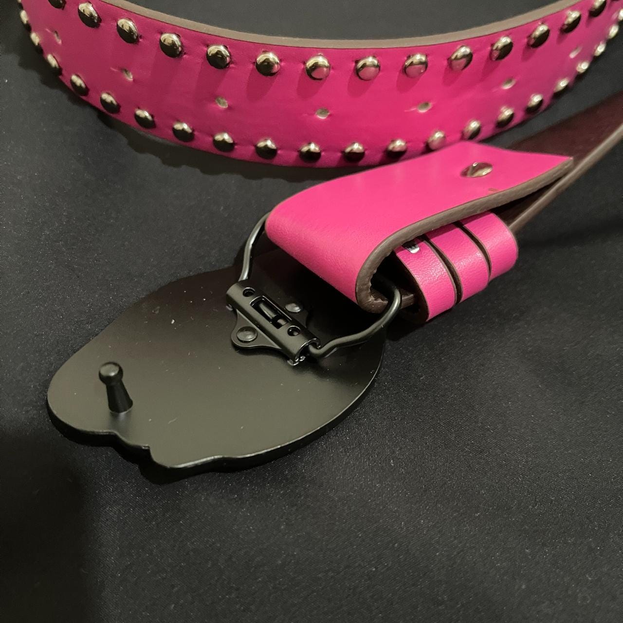 The reverse side of a ninja turtle buckle is shown, revealing its black metal fastening mechanism.