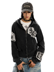 A woman with a "Los Angeles" cap and choker wearing a cropped, distressed, black, pocketless "Punk RockStar" hoodie.