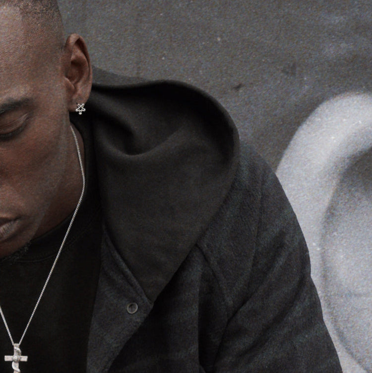 A man with black jacket wearing ABYSS STAR EARRINGS.