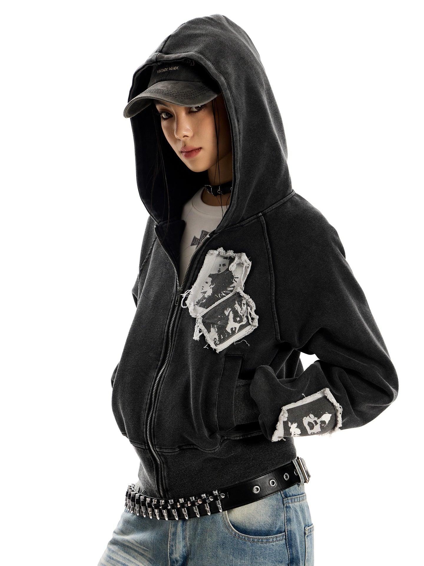 A model in a distressed black pocketless hoodie with a zip-up front.