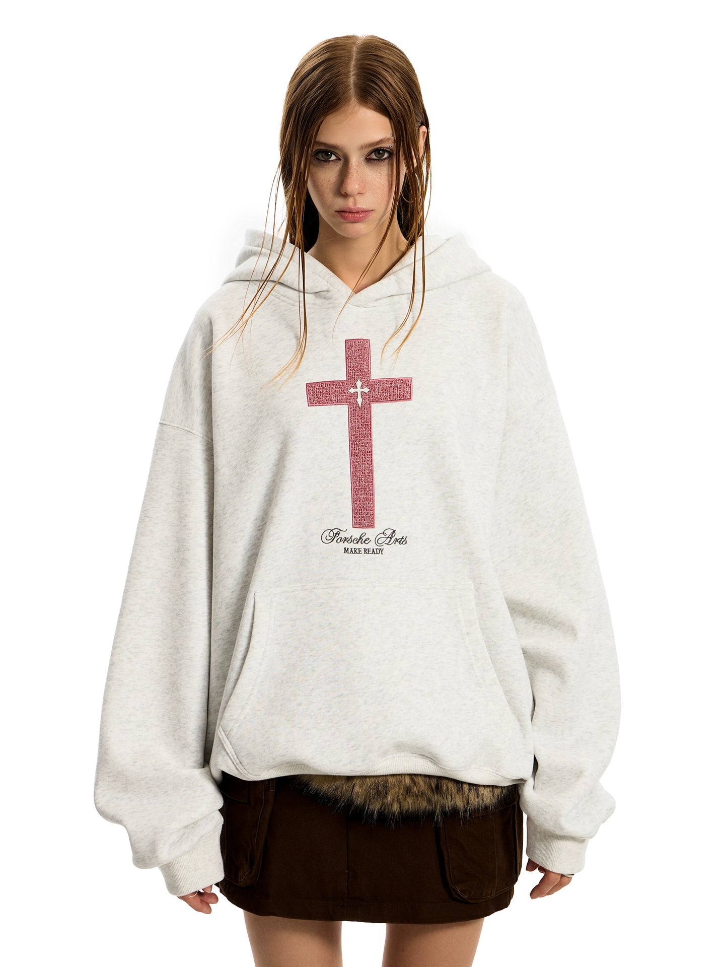 A woman with braided hair wears an oversized light grey GOTHIC HOODIE WOMEN featuring a distressed red cross design over a dark mini skirt.