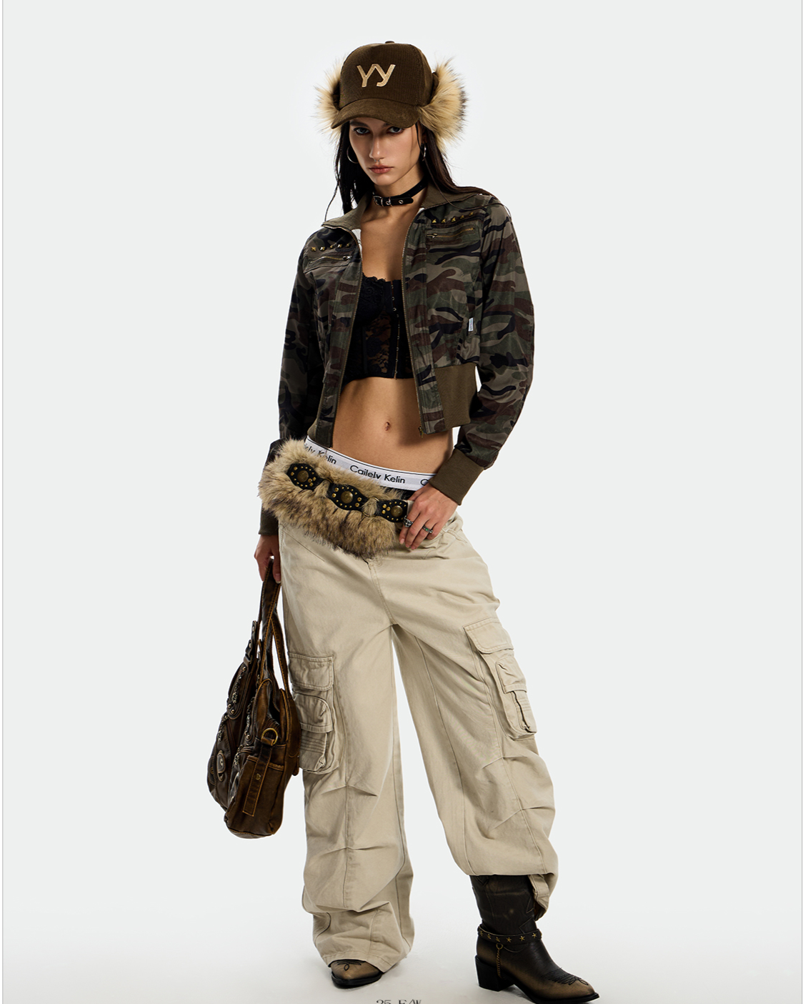 A woman modeling a cropped Rebel Camo Jacket with a matching fuzzy hat.