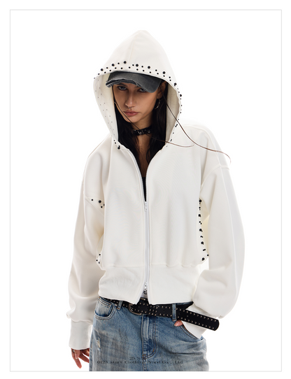A person with dark hair wears a white Wolf Street Hoodie with black stud detailing on the sleeves and hood.