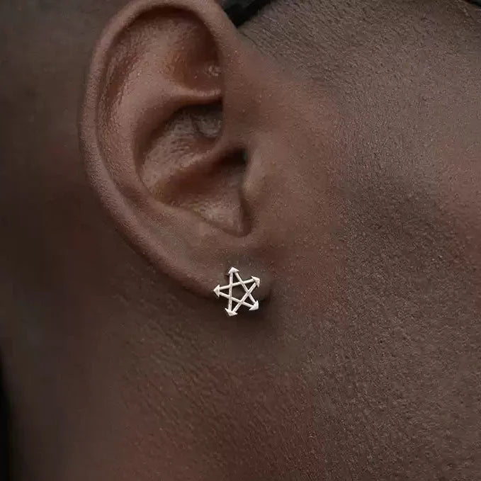 Close-up of a person wearing a ABYSS" STAR EARRINGS on the left ear.