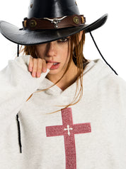 A woman suggestively biting her finger while wearing a light grey GOTHIC HOODIE for WOMEN with a red cross design.