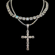 A shimmering "GODFATHER CROSS NECKLACE" made of multiple diamond-encrusted chains and a large cross pendant is displayed against a dark background.