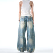 A person wearing a white tank top is shown from behind, modeling a pair of baggy Retro Washed Jeans.