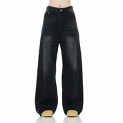  A model showcasing black washed wide leg jeans with a high-waisted fit.

