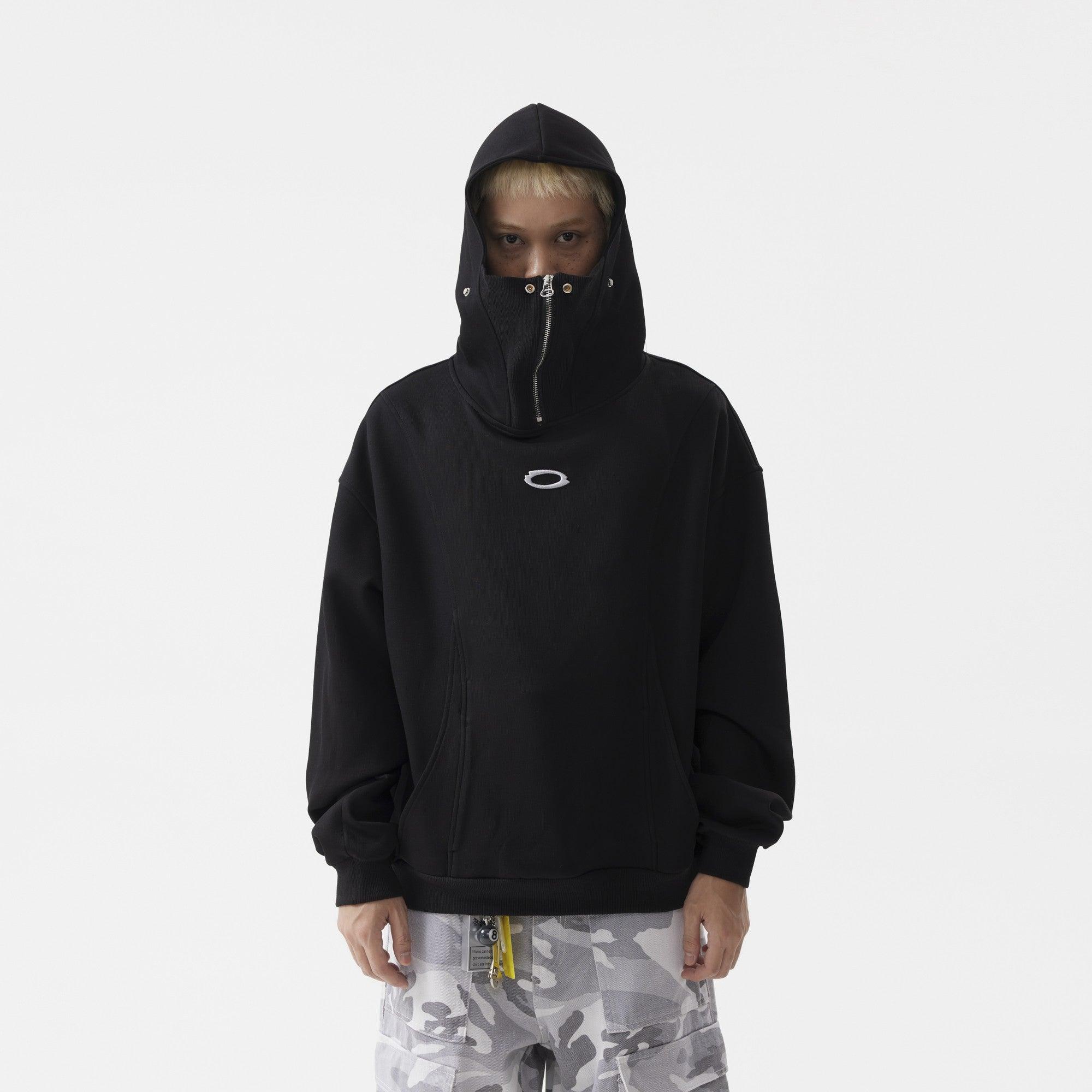 A young man wearing a black hoodie with mask that zips up to cover the lower half of his face.