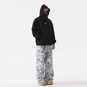A man with black masked hoodie with a zipper, paired with gray camouflage cargo pants and tan slippers, standing against a white background.