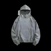 A plain gray hoodie with mask is displayed on a black background, with its zipper and hood featuring eyelets.