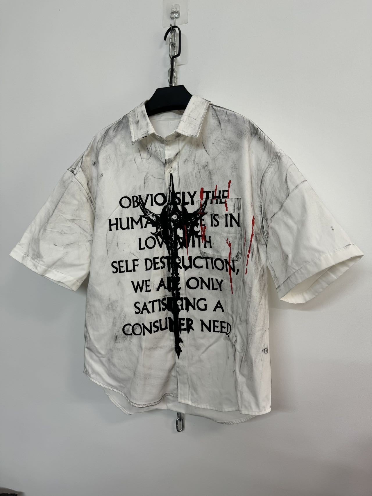 A white, distressed men's graffiti t-shirt with short sleeves, featuring black text.