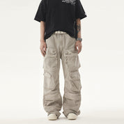 A person in the Philippines wears a black t-shirt and light beige Heavy duty Vibe Cargo Jeans with multiple large pockets, accessorized with a studded white belt and bracelet.