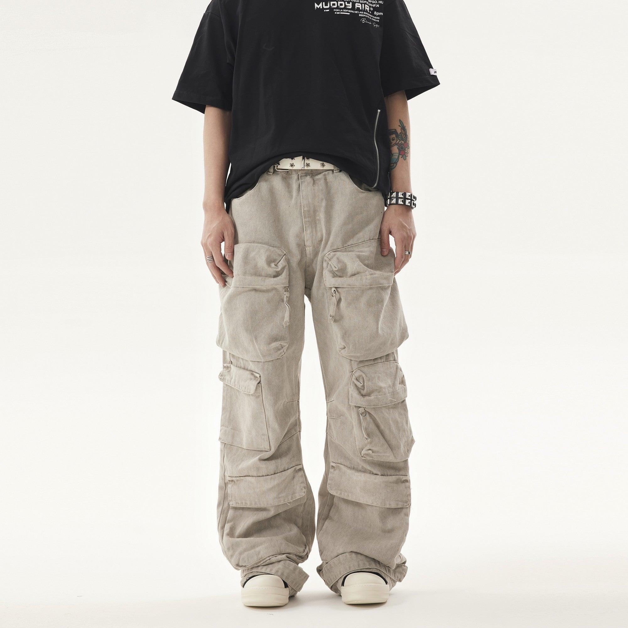 A person in the Philippines wears a black t-shirt and light beige Heavy duty Vibe Cargo Jeans with multiple large pockets, accessorized with a studded white belt and bracelet.