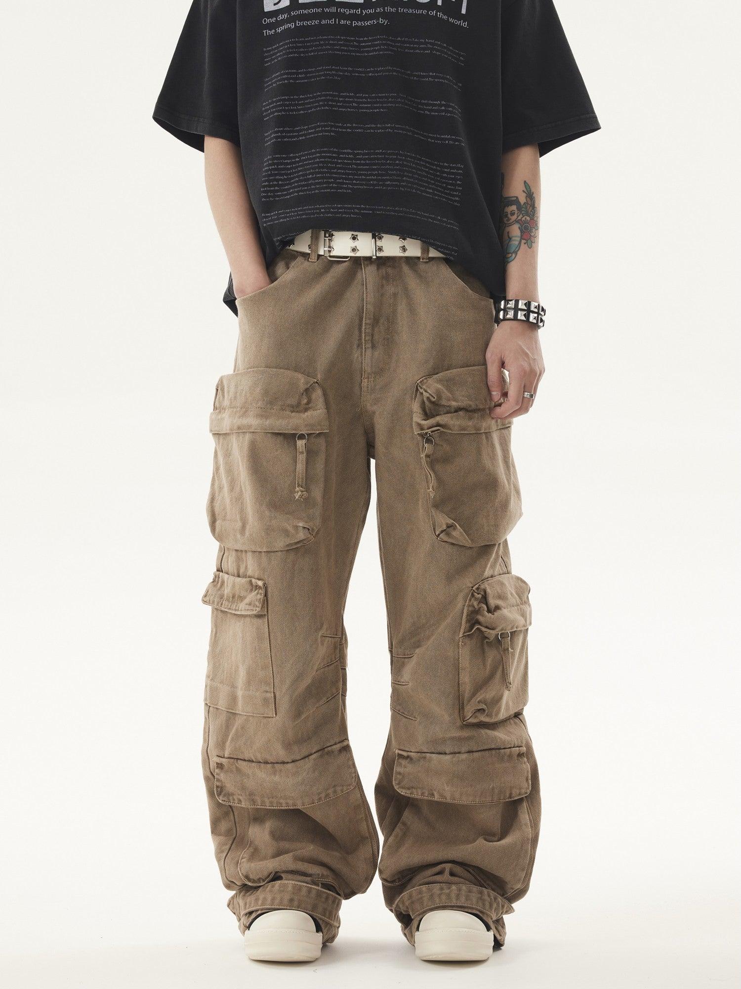 A person wears light brown Heavy duty Vibe Cargo Jeans with numerous cargo pockets, paired with a black t-shirt and a studded white belt.