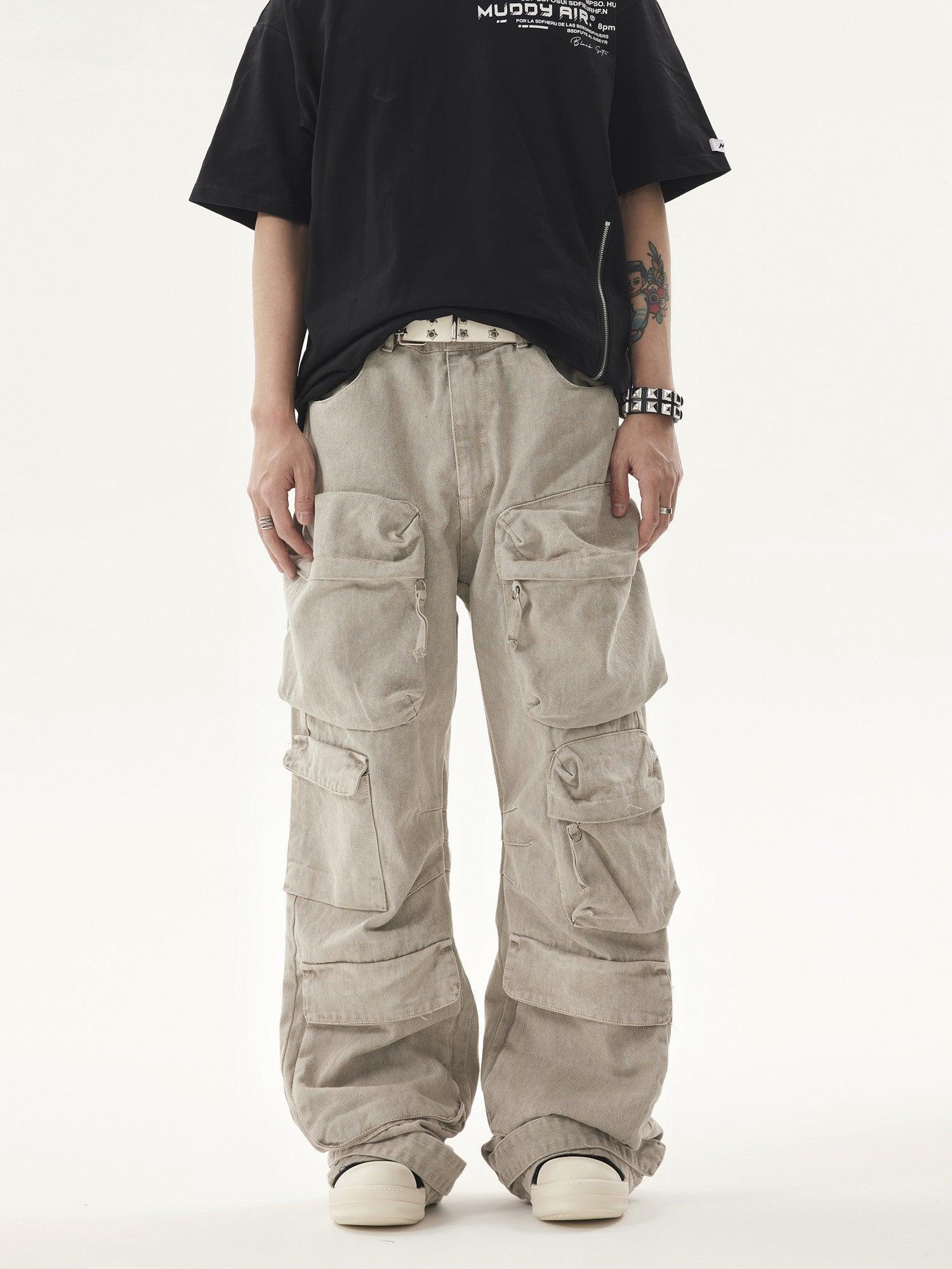 A person wears a black t-shirt and light-colored Heavy duty Vibe Cargo Jeans with numerous large cargo pockets, paired with a studded white belt and white sneakers.