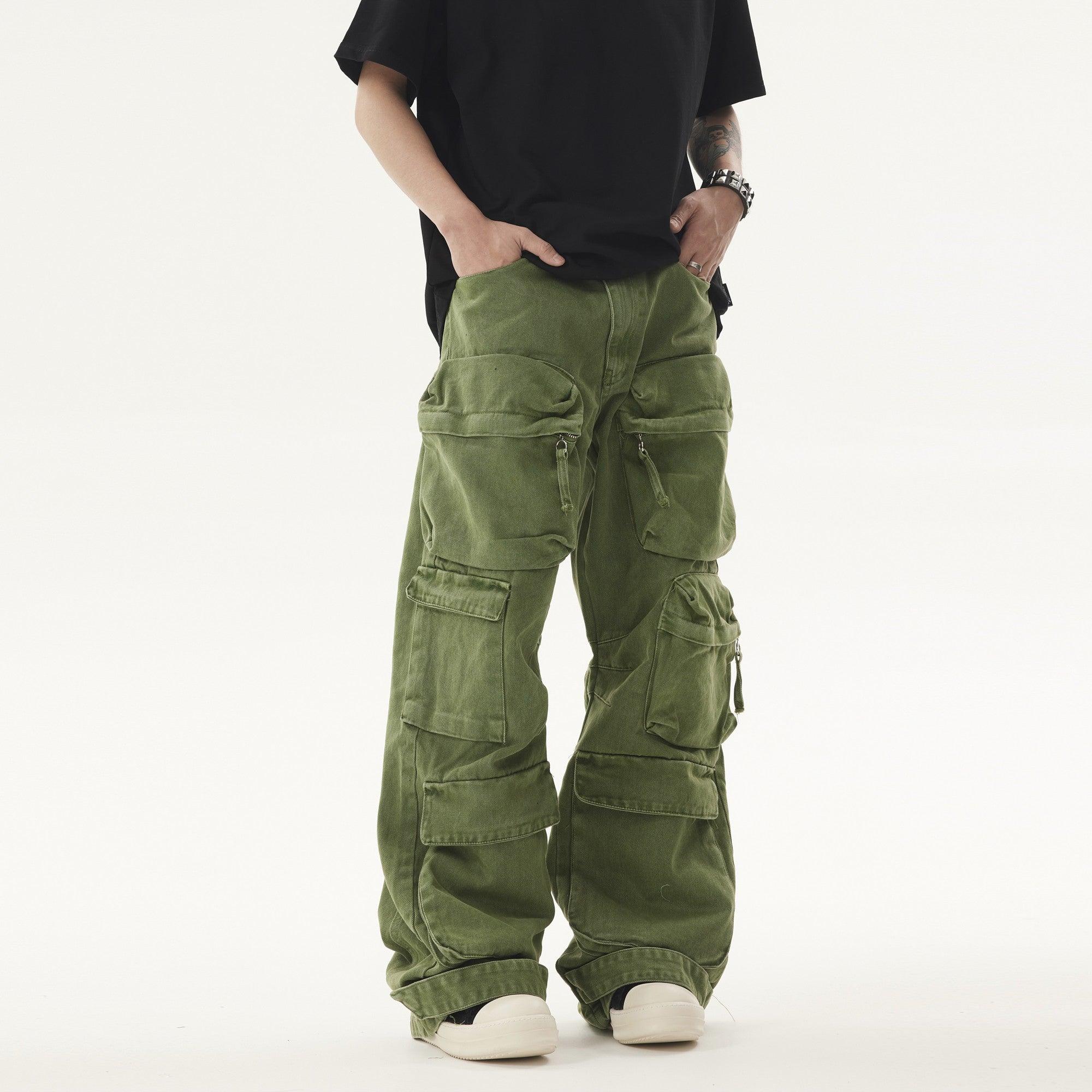 A person wears a black t-shirt and green Heavy duty Vibe Cargo Jeans with numerous large pockets, paired with white sneakers.