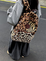 A woman holding a Multi Leopard Print Plush Backpack on her back.