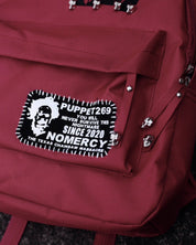 A close-up of the PT269 No Mercy Rivet Backpack highlights a patch with a man's face and "PUPPET269 SINCE 2020 NOMERCY"