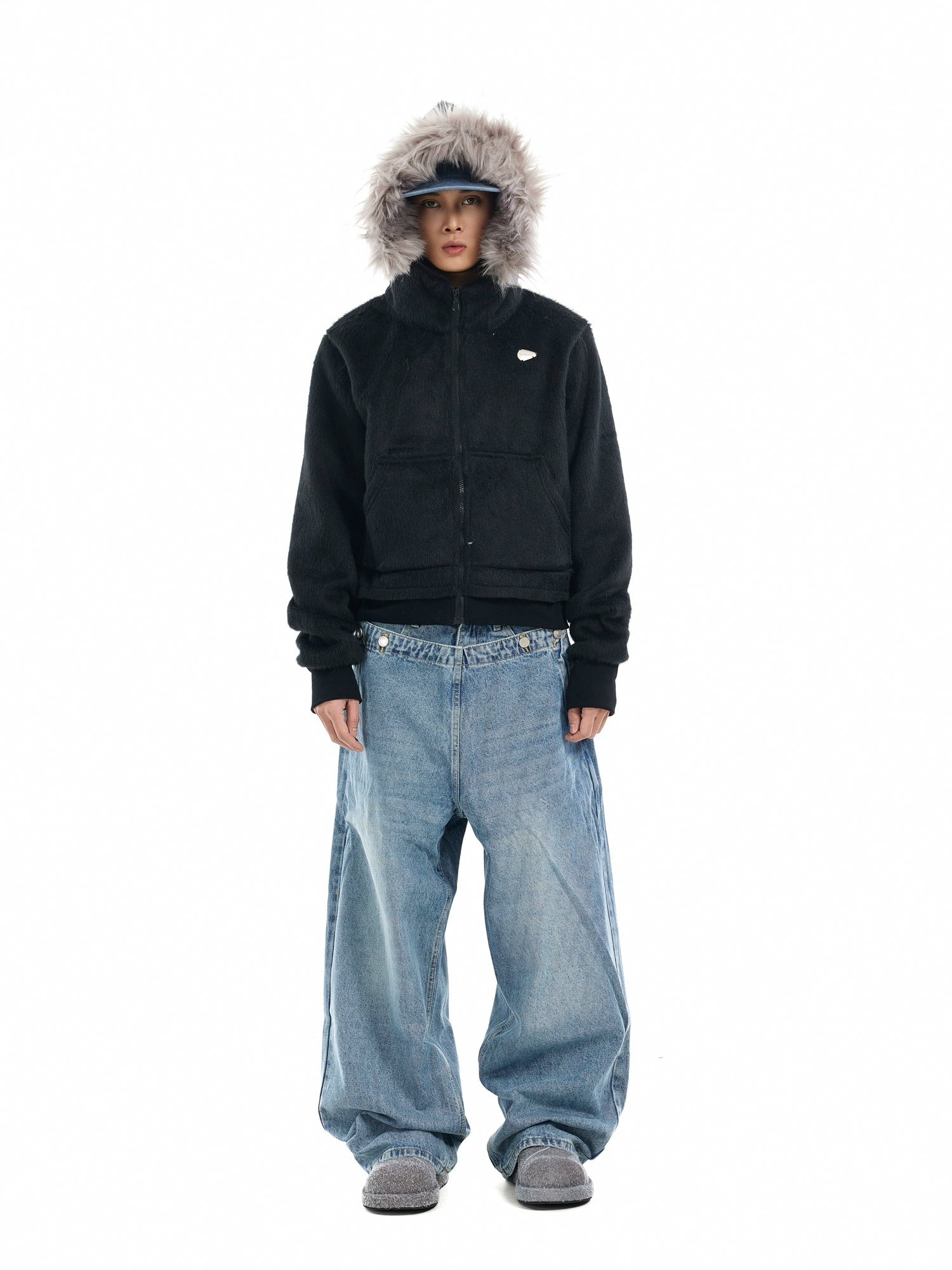 A person models a black "mens hooded faux fur jacket" with a grey faux fur-trimmed hood.