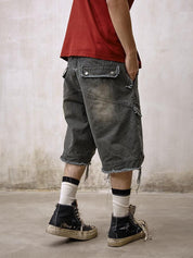 A person is shown from behind wearing a red t-shirt and Remedy Washed Tassel Workwear Jorts with large back pockets and a frayed, distressed hem, paired with dirty high-top sneakers and white and black striped socks.