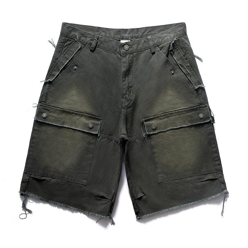 A pair of dark, distressed Remedy Washed Tassel Workwear Jorts with large cargo pockets and a frayed hem is displayed against a white background.