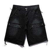Two pairs of distressed Remedy Washed Tassel Workwear Jorts—one black and one dark gray—are displayed, both featuring large front cargo pockets with metal snaps and frayed, tasseled hems.