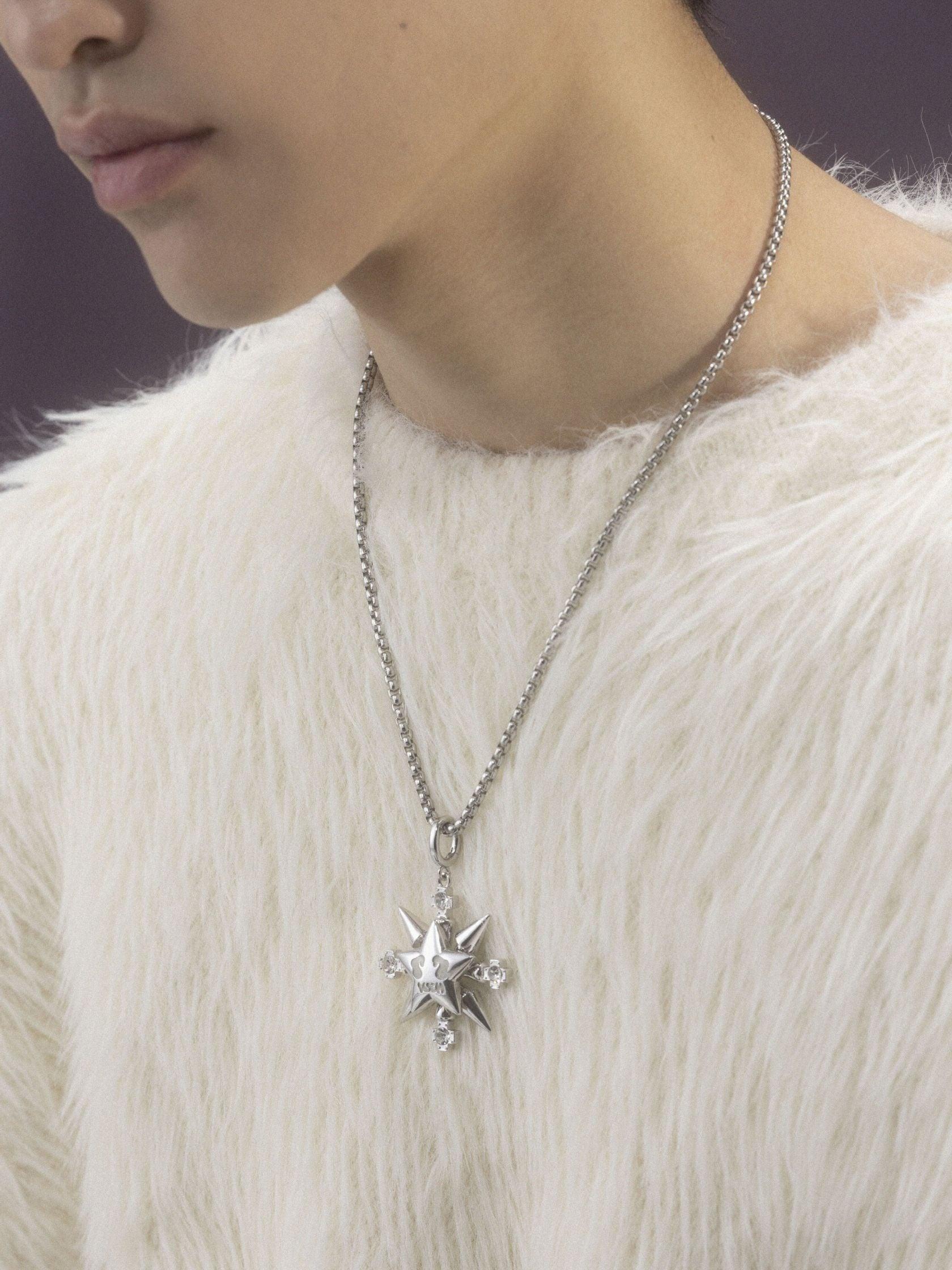 A person wearing a fluffy white sweater displays a silver "VSCH Lucky Star Necklace" with a detailed star pendant.