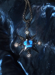 A shiny silver "VSCH Lucky Star Necklace" with a star pendant and blue and diamond accents rests on a reflective blue surface.
